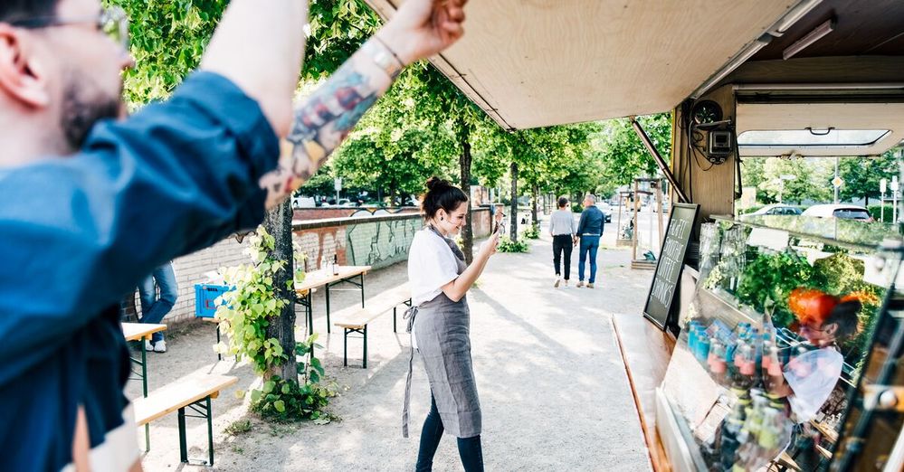 Two young business people opening an awning on their food stall.jpg