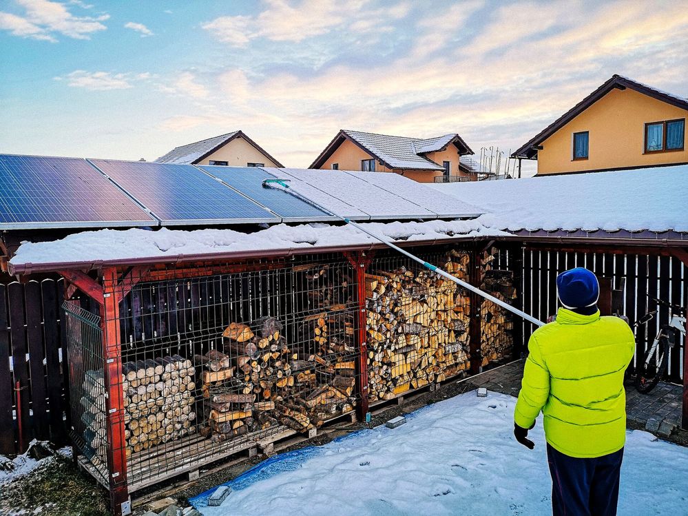 Large_MS PPT_Web-Person cleaning snow from the solar panels on their wood store.jpg