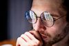 Large_MS PPT_Web-A man wearing round eyeglasses looking at a computer screen (1).jpg