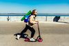 Large_MS PPT_Web-Woman with yoga mat rides scooter at seaside.jpg