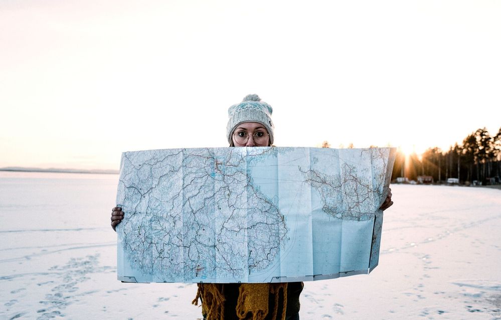 Large_MS PPT_Web-A woman in a woolly hat holding a map in a frozen landscape.jpg