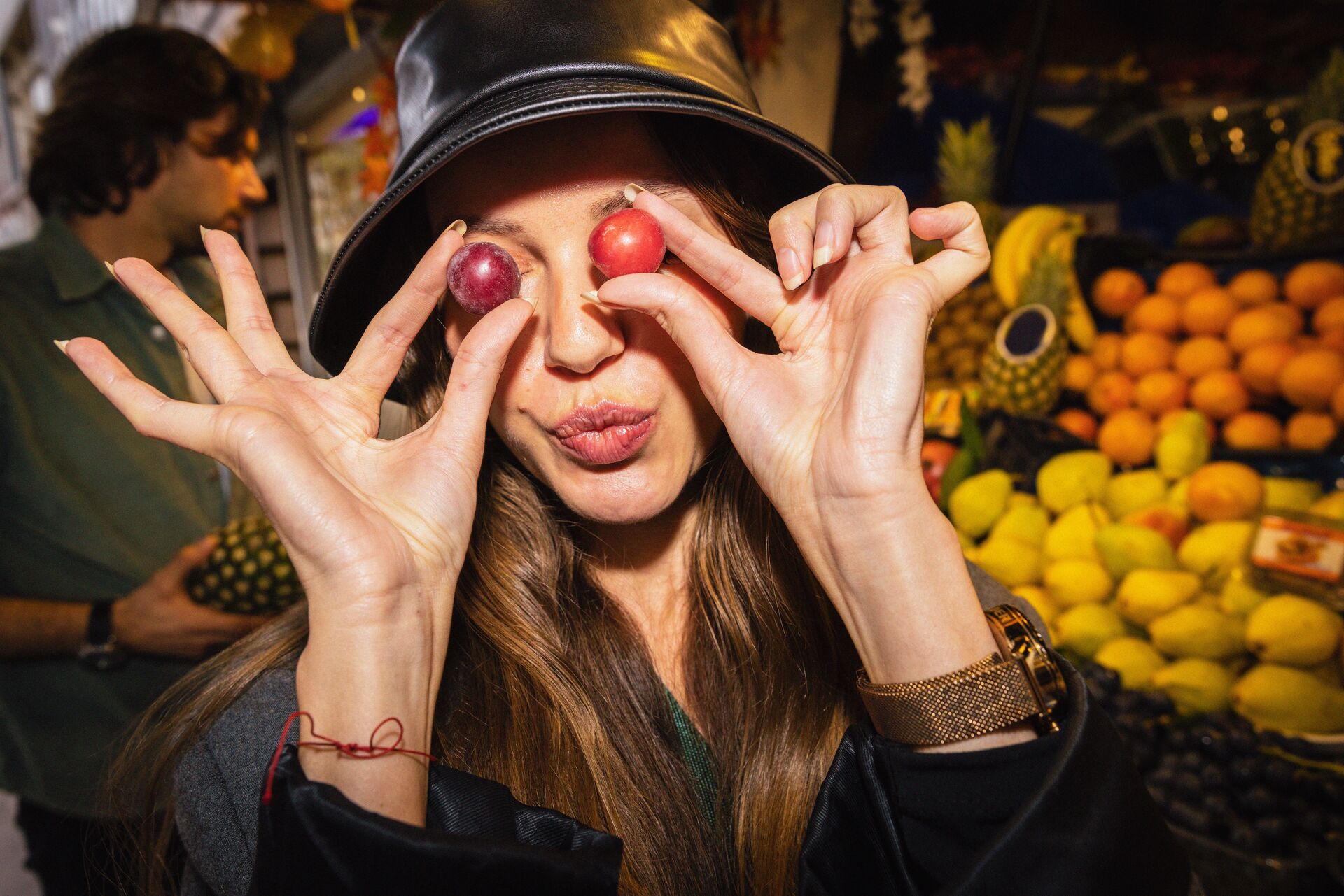Large_MS PPT_Web-Woman with a hat holding grapes in front of her eyes.jpg