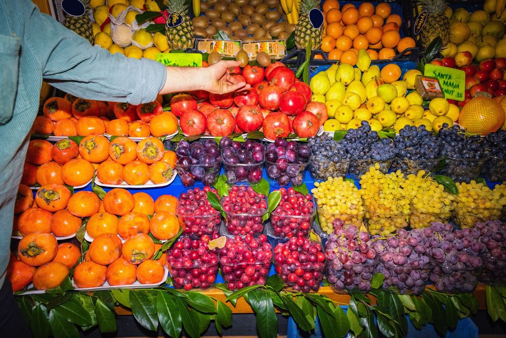 Large_MS PPT_Web-A man points to pomegranates on a fruit stand.jpg