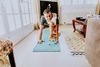 Large_MS PPT_Web-A man gets interrupted by his small dog while standing in a yoga position on a mat in the living room.jpg