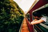 Large_Web and Screen-A man hangs outside a train window to look at the scenery during the ride.jpg