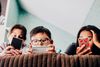 Large_Web and Screen-Three children lying on a bed and looking at their phones.jpg