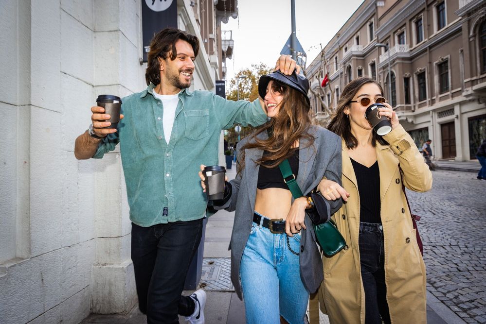 Large_Web and Screen-Three friends smiling while drinking coffee and walking down the street.jpg