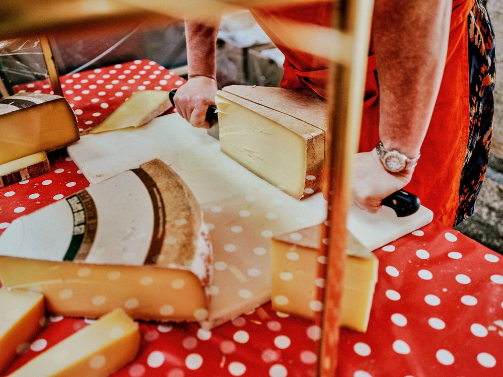 Large_Web and Screen-Person slicing pieces of cheese on cutting board.jpg